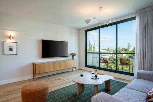 a living room with a tv and a couch and a table at master Mazeh in Tel Aviv