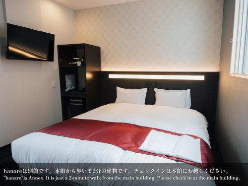 a bedroom with a large bed with a red blanket at Kansei 京都八条 in Kyoto