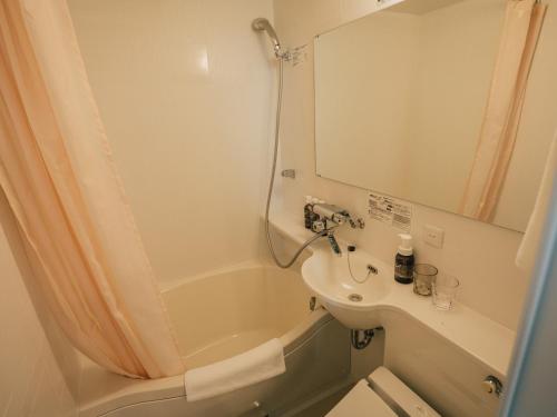 a bathroom with a sink and a tub and a toilet at Kansei 京都八条 in Kyoto
