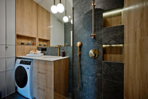 y baño con lavadora y ducha. en BlueApart Kaszubska Bryza Hel, en Hel