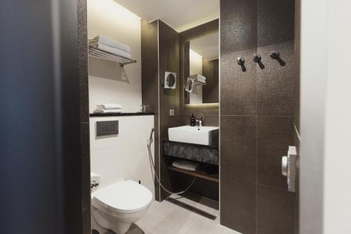 a bathroom with a toilet and a sink at Home Hotel Jugend in Helsinki