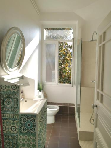 une salle de bain avec un lavabo et des toilettes et une fenêtre dans l'établissement 117m2 - spacieux et lumineux, à Périgueux