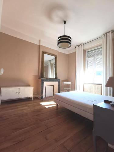 une chambre avec un grand lit et un miroir dans l'établissement 117m2 - spacieux et lumineux, à Périgueux