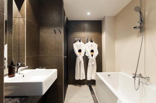 a bathroom with a sink and a bath tub and a sink at Home Hotel Jugend in Helsinki