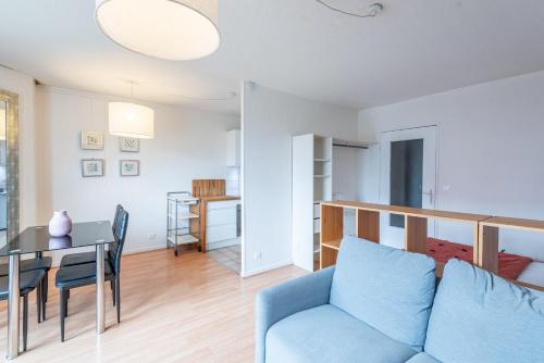 un salon avec une table et un canapé bleu dans l'établissement M78 Marquer studio Château Rouge, à Annemasse