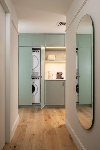 a laundry room with a mirror and a washer and dryer at master Mazeh in Tel Aviv