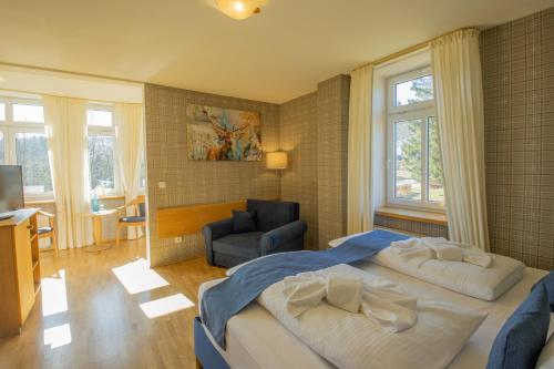 a bedroom with a large bed and a living room at Ferien Residenz Thüringer Wald in Masserberg