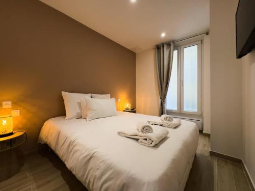 une chambre avec un grand lit blanc avec des serviettes dessus dans l'établissement Penbed - Montparnasse - 1BR, à Paris