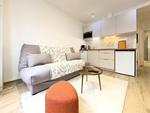 un salon avec un canapé et une table et une cuisine dans l'établissement Penbed - Montparnasse - 1BR, à Paris
