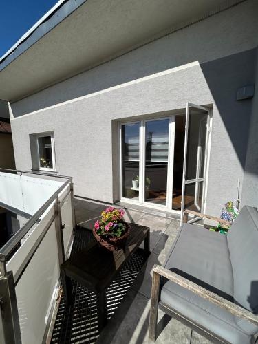 a balcony with a chair and a table with flowers at Apartmán Raková NO1 in Raková