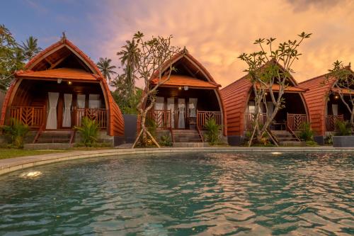 a house with a swimming pool in front of it at Lumbung River Ubud Villas in Blahbatu