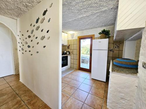 a kitchen with a wall with shoes on the wall at SPLENDIDA VILLA SOS ARANZOS SPIAGGIA PRIVATA in Pittulongu