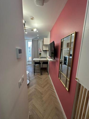 Cette chambre est dotée d'un mur rose avec une table et un miroir. dans l'établissement MOON - 43, à Nice