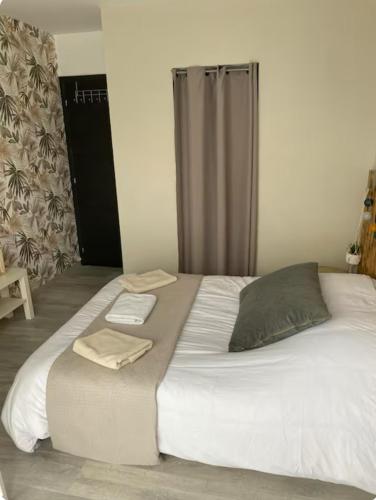 un grand lit avec deux serviettes dessus dans l'établissement Ma chambre côté Bassin, à Audenge