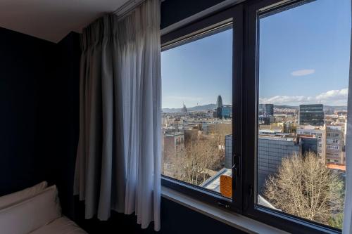 a room with a window with a view of a city at Travelodge Barcelona Poblenou in Barcelona