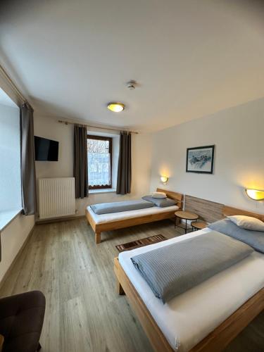 a hotel room with two beds and a projection screen at Goldener Adler in Scharnitz