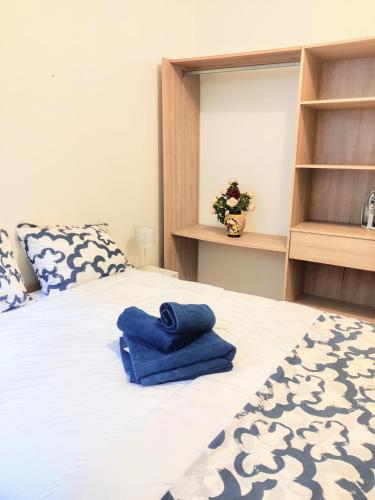 une chambre avec un lit avec des serviettes bleues dessus dans l'établissement Le cocon du XVII, à Paris
