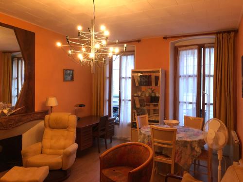 d'un salon avec une table à manger et un lustre. dans l'établissement Hébergement Flotiane, à Belley