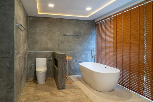 a bathroom with a large tub and a toilet at Villa Tiwera 6br Private Pool & Sea View in Chaweng Noi Beach