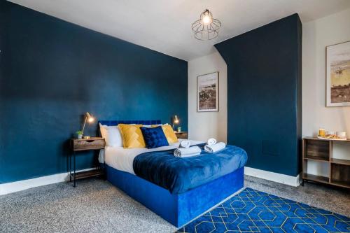 ein blaues Schlafzimmer mit einem Bett und einer blauen Wand in der Unterkunft Sleeps 8 Ps5 Pool Table in Wellingborough