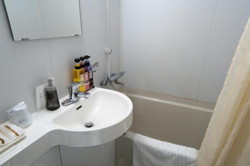 a bathroom with a sink and a bath tub at Ramada Encore by Wyndham Amagasaki in Amagasaki