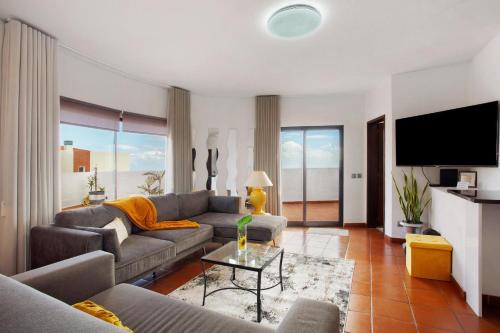 Una sala de estar con un sofá y un televisor. en Apartamento Lolita com Terraço, en Caniço