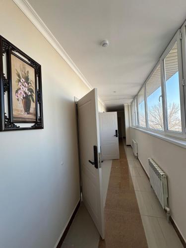 an empty hallway with a refrigerator and a window at Harmony Inn in Almaty