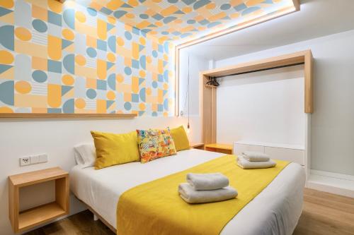 Un dormitorio con una cama con toallas. en Eleven Boutique Apartments by Airnest, en Las Palmas de Gran Canaria