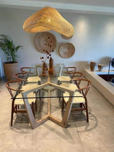 a glass dining room table with chairs and a lamp at Relax in Style at this Stunning Villa in Camps Bay, Cape Town in Cape Town