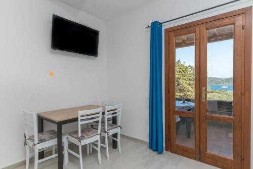 a room with a table and a television and a door at Seaview E9 in Proiettore