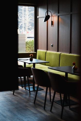a room with two tables and a green couch at Alphotel Innsbruck in Innsbruck