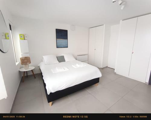 une chambre blanche avec un lit et des armoires blanches dans l'établissement Very lovely apartment Bordeaux, à Bordeaux