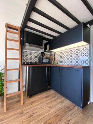 une cuisine en mezzanine avec des placards bleus et une échelle dans l'établissement Studio cosy en plein cœur de Nice, à Nice
