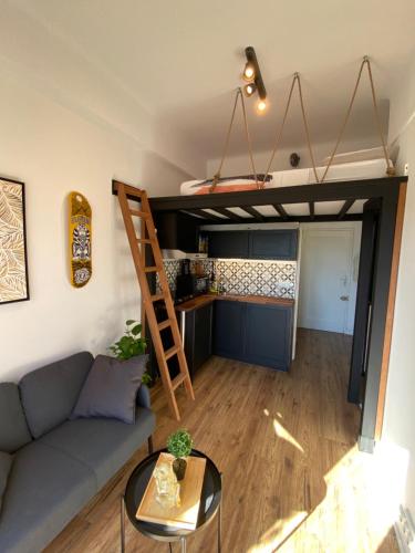 - un salon avec un canapé et une mezzanine dans l'établissement Studio cosy en plein cœur de Nice, à Nice