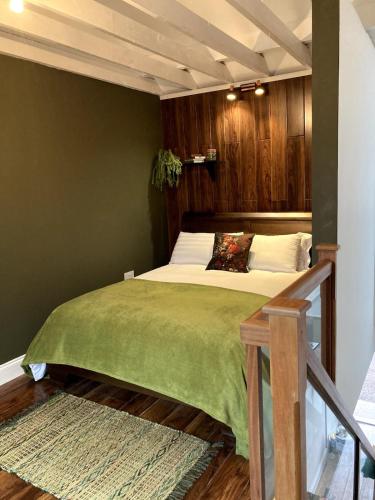 a bedroom with a bed with a green comforter at The Nest in Annascaul