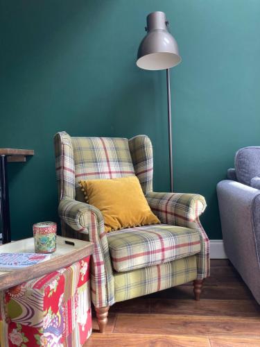 a living room with a chair and a lamp at The Nest in Annascaul