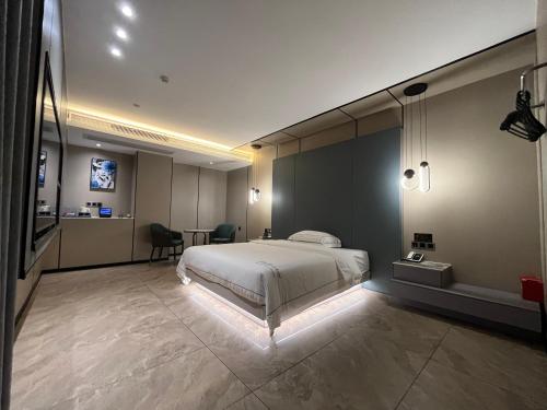 a bedroom with a bed and a table and a desk at Mehood Hotel Leizhou Maodegong Drum City in Zhanjiang