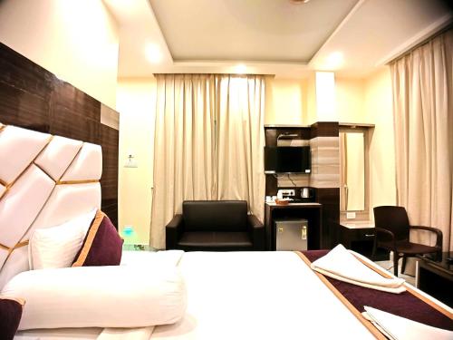 a hotel room with a large bed and a chair at Elegant Beach Resort in Mandarmoni