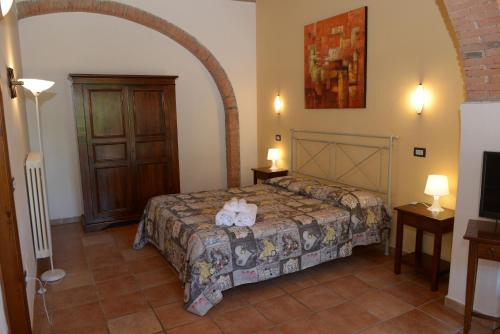 a bedroom with a bed with two teddy bears on it at Borgo San Martino - Residence Hotel & SPA in Riparbella