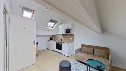 un salon avec un canapé et une cuisine dans l'établissement Appartement Cosy Gare Nanterre Ville RER A, à Nanterre