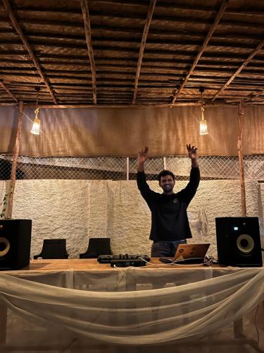 a man standing on a stage with his arms in the air at HOT - HOUSE OF TRAVELLERS, Vagator in Vagator