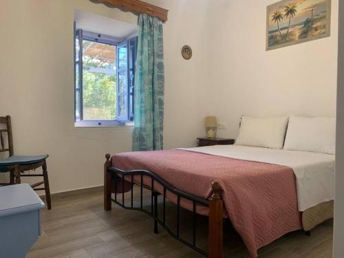 een slaapkamer met een groot bed en een raam bij Aloe House in Patmos
