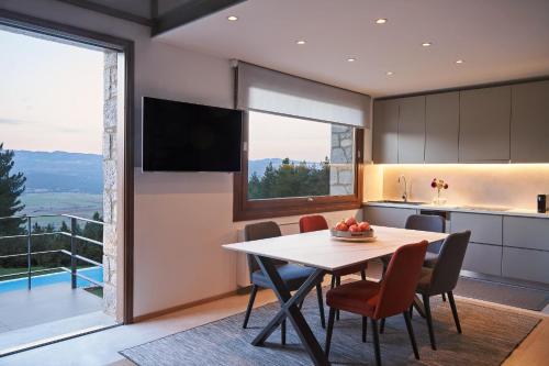 a kitchen and dining room with a table and chairs at Alti Luxury Villa in Amfiklia