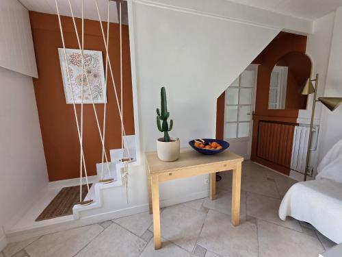 un salon avec une table et un cactus dans l'établissement Charmante maison bretonne 400 m des plus belles plages, à Plouguerneau