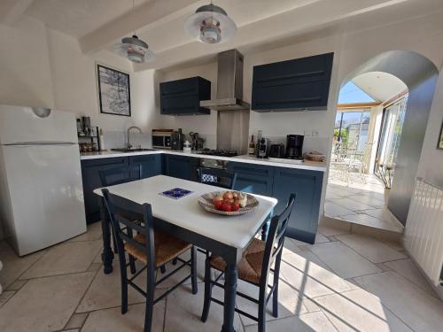 une cuisine avec une table avec un bol de fruits dessus dans l'établissement Charmante maison bretonne 400 m des plus belles plages, à Plouguerneau