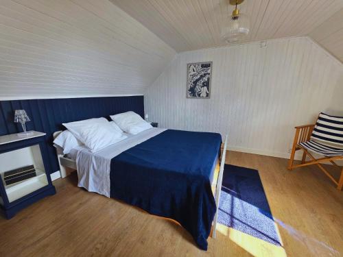 une chambre avec un lit, une table et une chaise dans l'établissement Charmante maison bretonne 400 m des plus belles plages, à Plouguerneau