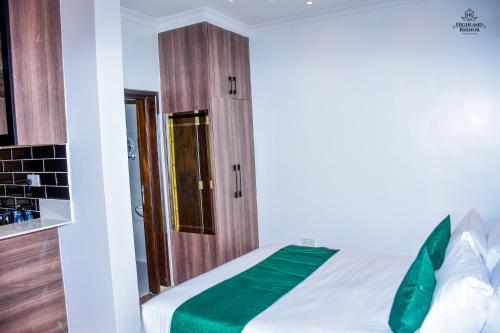 a bedroom with a bed with a green blanket at Highland Rhinor in Eldoret