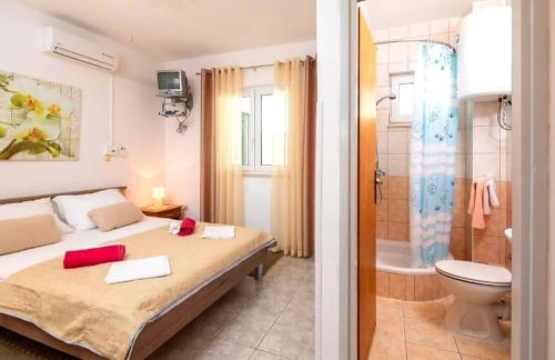 a bedroom with a bed and a bathroom with a shower at Apartment Complex in Lokva Rogoznica in Lokva Rogoznica