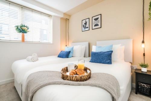 two beds in a bedroom with a tray of food at Stylish Decor Close to Vibrant O2, Canary Wharf & Isle of Dogs in London