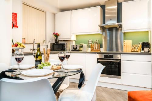 a kitchen with a table with glasses of wine at Stylish Decor Close to Vibrant O2, Canary Wharf & Isle of Dogs in London